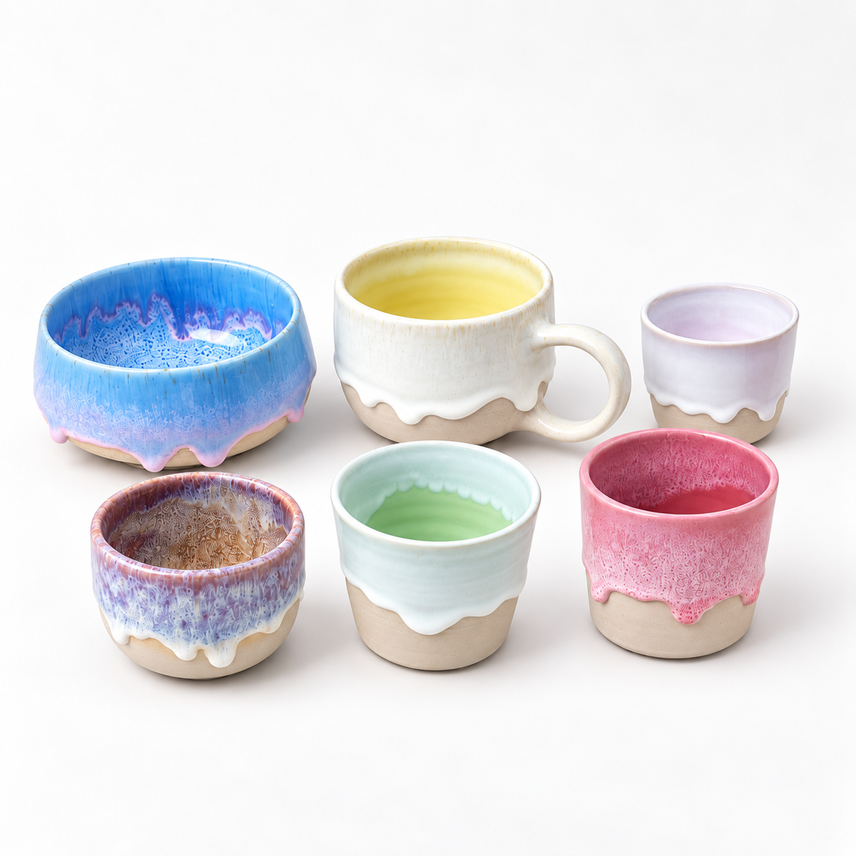 Handgefertigte Keramikbecher mit farbigen Tropfenglasuren in Rosa, Blau, Grün und Gelb für den Drops on Pots Kurs